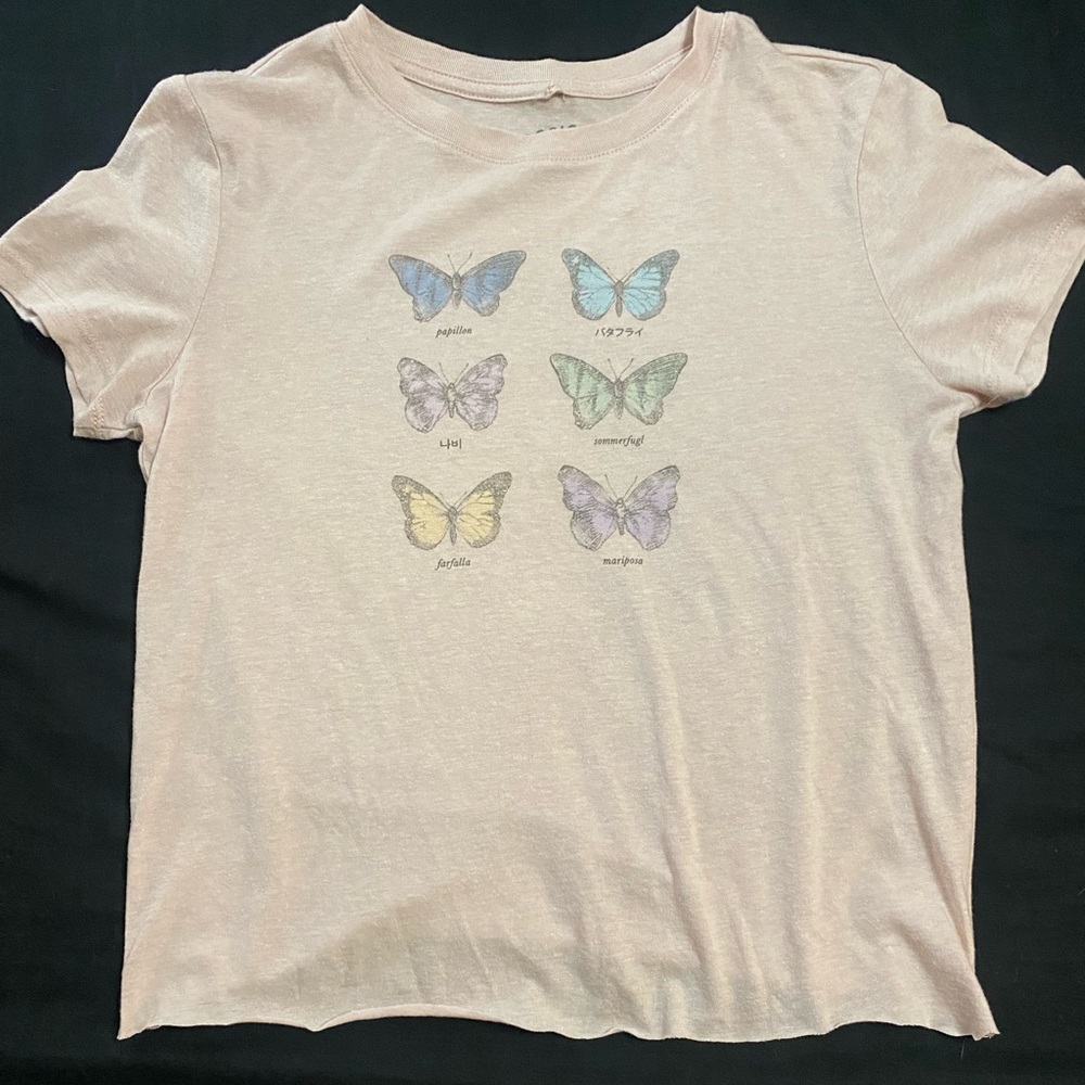 A cropped shirt with butterflies in multiple languages